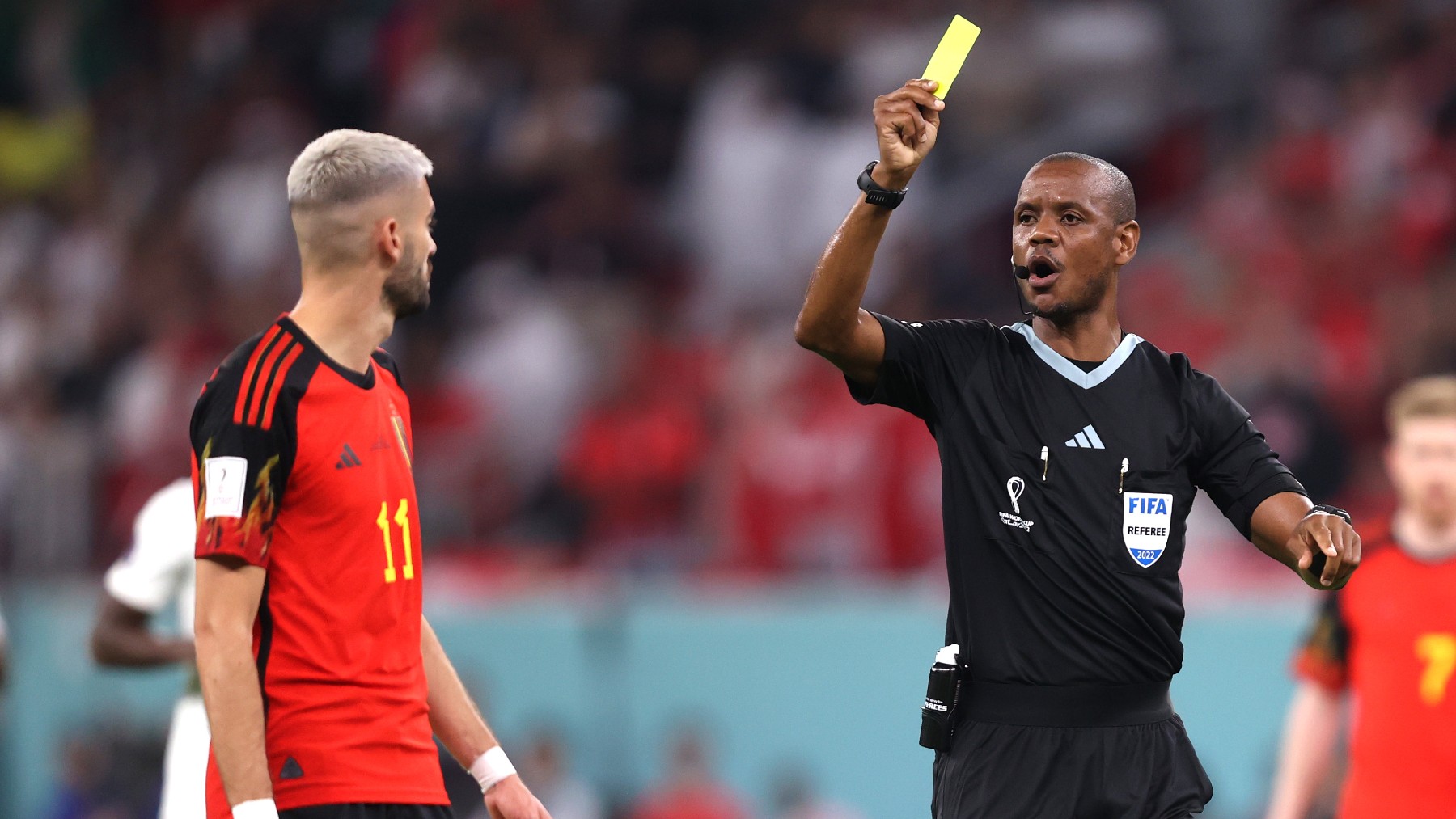 El árbitro enseña una tarjeta amarilla a Carrasco en el Mundial de Qatar 2022. (Getty)